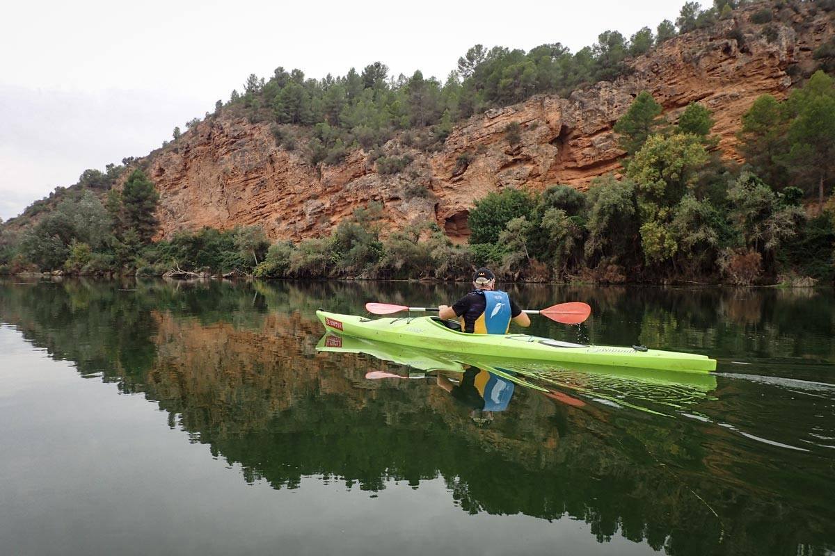 un caiac individual passant per sota d'un penyassegat anomenat la Roca Roja