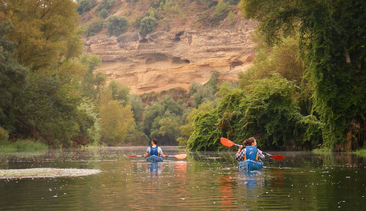dos persones anant en caiac dabant d'un penyasegat del riu Ebre