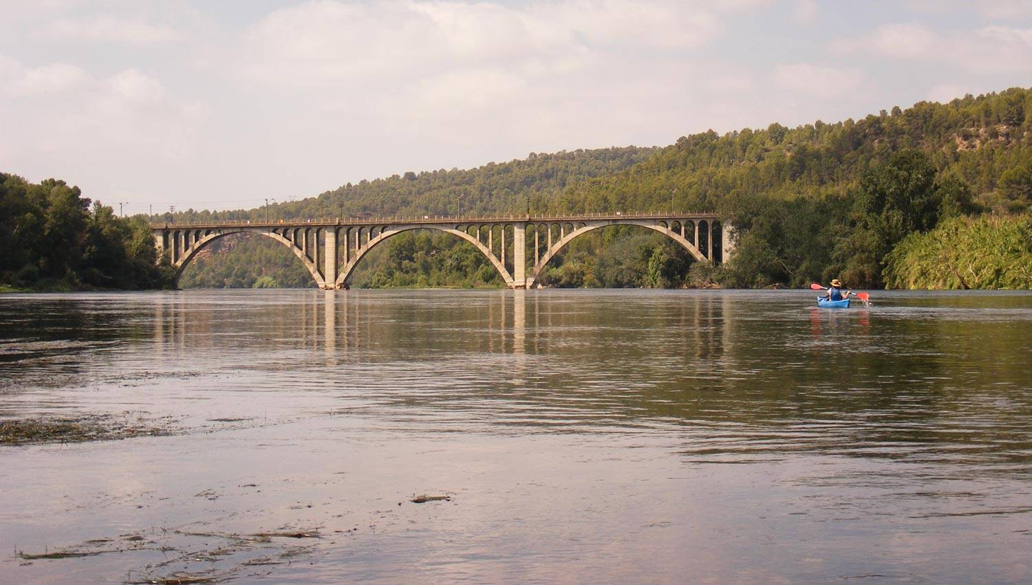 paisatge del l'Ebre amb un piragüista i el pont de Garcia al fons